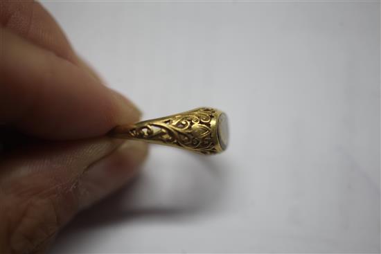 An antique scroll-pierced yellow metal ring set with an oval diamond,